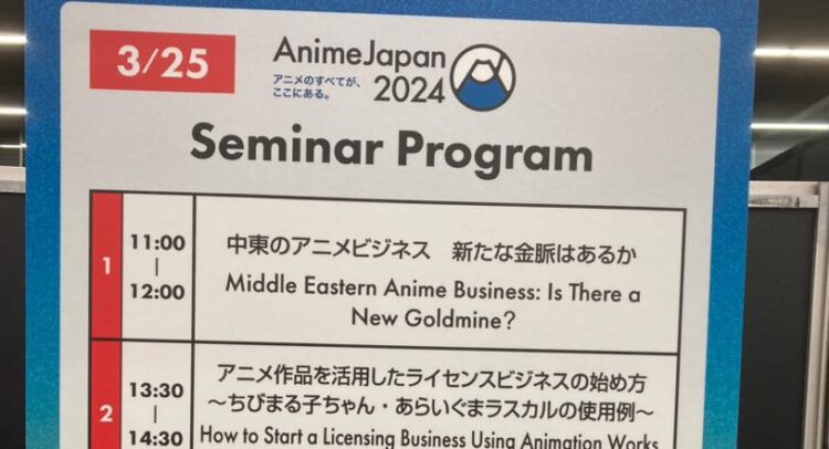 AnimeJapan 2024のセミナープログラムを示す掲示板。日付は3月25日。青い背景に、富士山をモチーフにしたAnimeJapan 2024のロゴが表示されています。 セミナーの内容は以下の2つです： 11:00から12:00 - 「中東のアニメビジネス 新たな金脈はあるか」 13:30から14:30 - 「アニメ作品を活用したライセンスビジネスの始め方 〜ちびまる子ちゃん・あらいぐまラスカルの使用例〜」 各セミナーのタイトルは日本語と英語で表記されています。