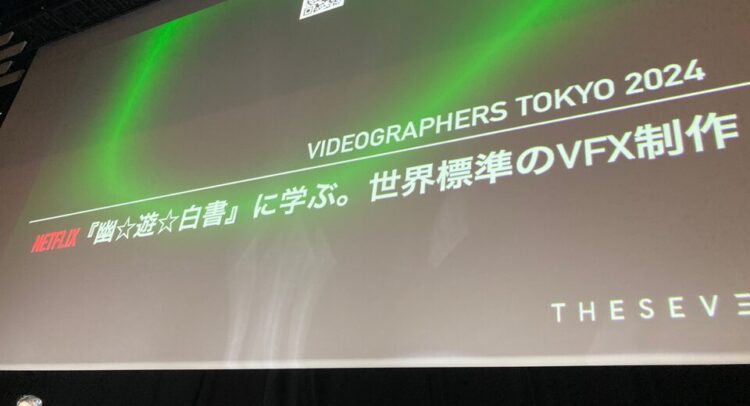 この写真は「Videographers Tokyo 2024」のイベントで、Netflixによる実写化作品『幽☆遊☆白書』に関するセッションの一場面を撮影したものです。プレゼンテーションのテーマは「世界標準のVFX制作」で、視覚効果（VFX）に焦点を当てた内容であることがわかります。 画面には「Netflix」のロゴと共に、『幽☆遊☆白書』について学ぶ内容が記されています。