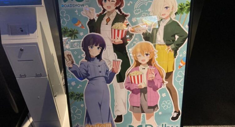 この画像は映画館のDolby Cinemaでの展示ポスターのようです。ポスターには、アニメ映画「虹ヶ咲学園スクールアイドル同好会」のキャラクターたちが描かれています。キャラクターたちはポップコーンや飲み物を手にしており、映画鑑賞の雰囲気を表しています。9月6日（金）に公開されることが強調されています。 背景には夏を感じさせるヤシの木やアイスクリームのイラストが散りばめられ、楽しい映画体験を連想させます。