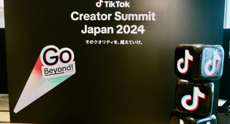 この写真は「TikTok Creator Summit Japan 2024」というイベントの会場を撮影したものです。背景には「そのクオリティを、超えていけ。」というキャッチフレーズが掲げられ、TikTokがクリエイターたちに向けてさらなる成長を促すメッセージが伝えられています。また、TikTokのロゴが描かれたキューブが積まれており、イベントの雰囲気を演出しています。「Go Beyond!」というスローガンが強調され、コンテンツクリエイターに新たな挑戦を促す姿勢が感じられます。