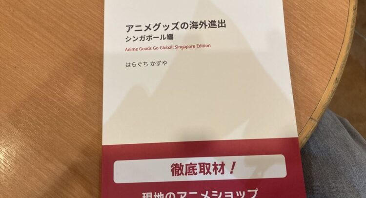 アニメグッズの海外進出に関する資料。シンガポール版。はらぐちかずや氏による徹底取材で、現地のアニメショップやAFA Singapore 2024の様子が写真付きで紹介されています。『徹底取材！』と記載されており、詳細な情報が期待できます。